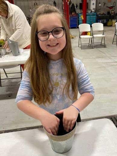 girl making bird feeder